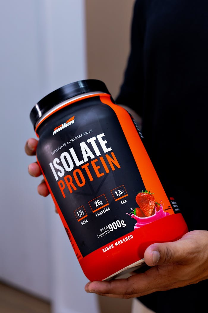 our-experience Close-up of a hand holding an Isolate Protein container in Belo Horizonte, Brazil.